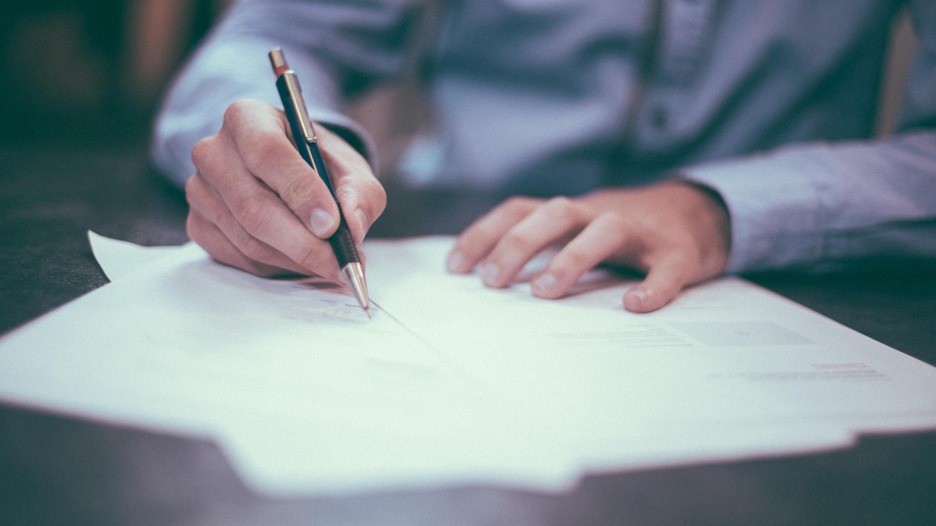 man writing on paper